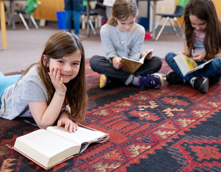 girl smiling with book and friends