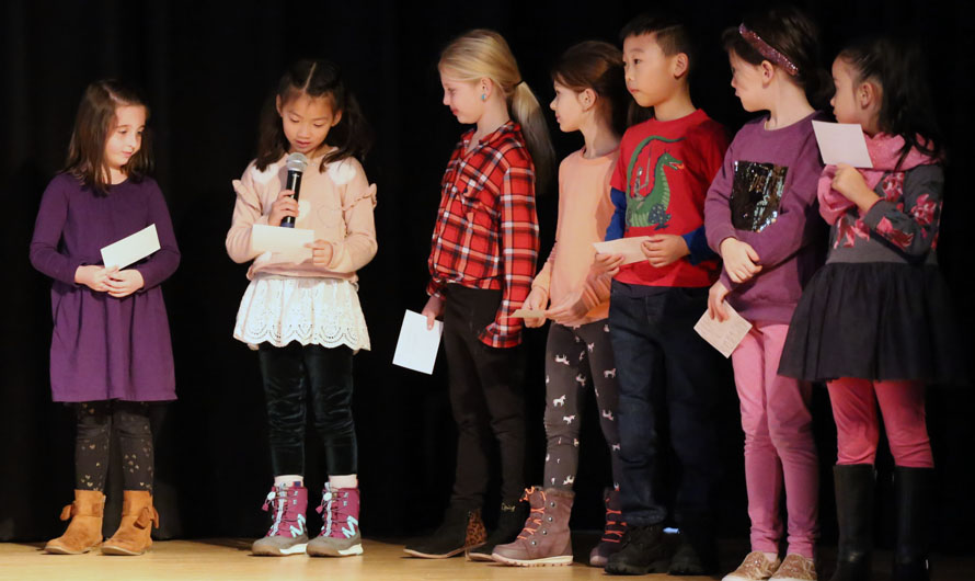 children on stage with microphones