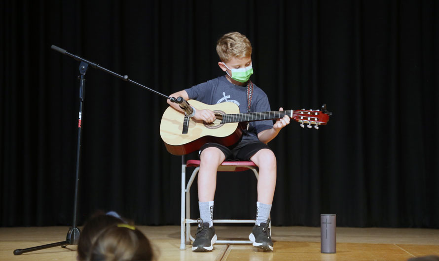 boy playing the guitar on stage