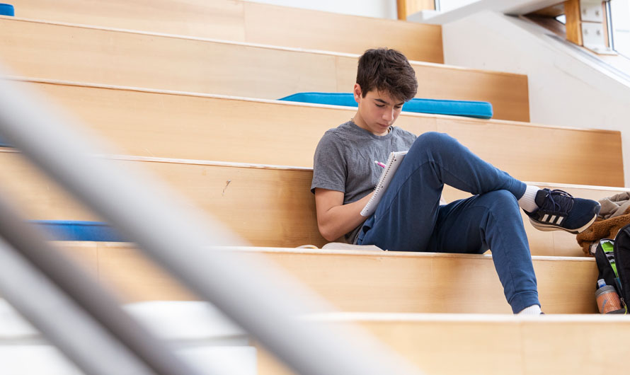 student reading book on stairs