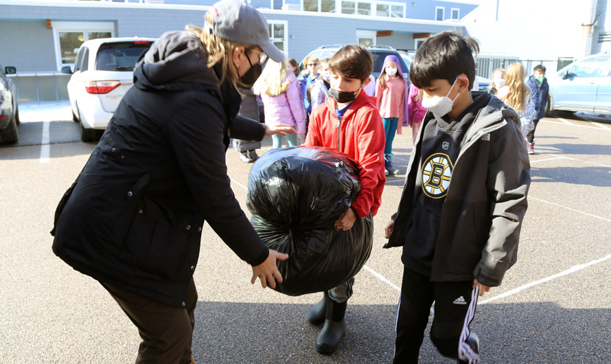 children and woman holding a trash bag