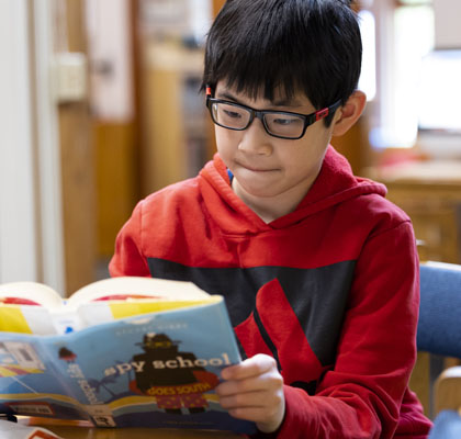 boy with glasses reading book