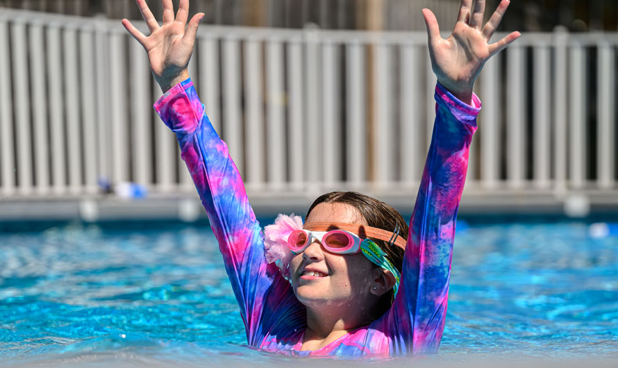 girl swimming in pool with goggles
