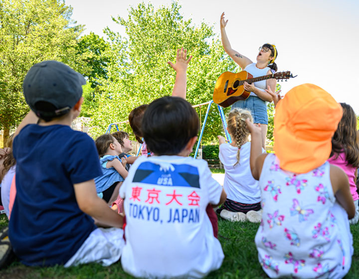woman playing a guitar for children