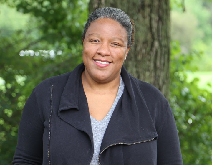 woman smiling in front of tree