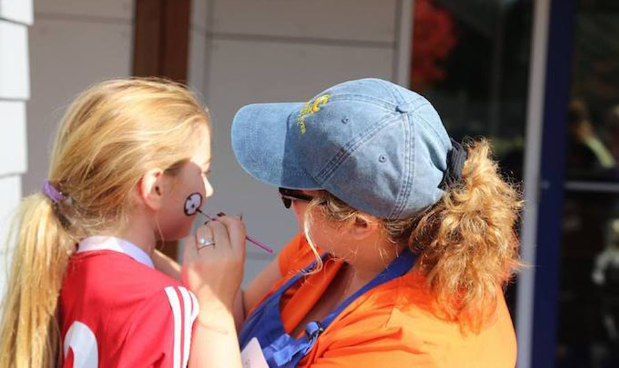 woman facepainting a little girl