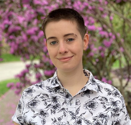 person smiling in front of trees