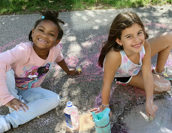 Two girls drawing with chalk