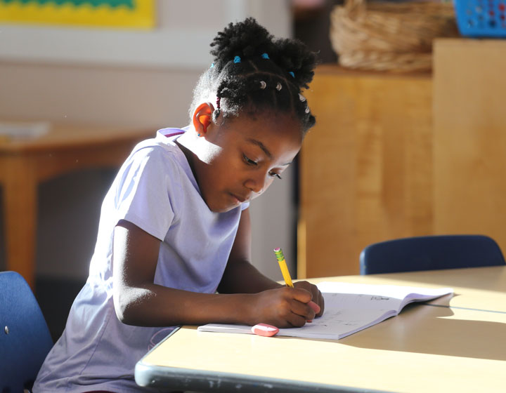 Girl writing at table